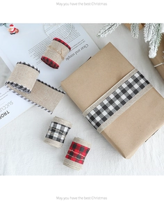 Close-up of rustic burlap Christmas ribbons with buffalo plaid edges on gift boxes