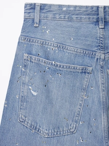 Détail de la poche arrière du jean bleu clair avec des strass étincelants