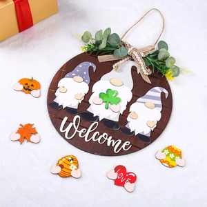 Detail of wooden welcome door sign with interchangeable seasonal icons and green foliage