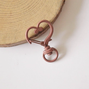 Macro view of matte rose pink heart-shaped alloy lobster clasp with a 360-degree swivel ring