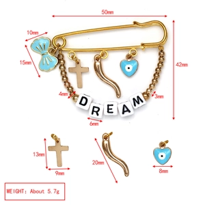 Detailed view of evil eye brooch with blue bow, dream beads and gold tone charms