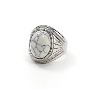 Macro detail showing vintage silver ring with oval white turquoise and intricate carvings