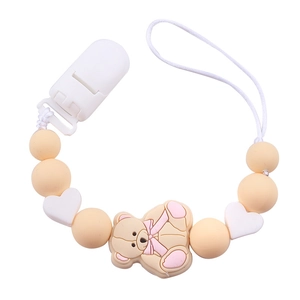 Dettaglio della catenella per ciuccio in silicone con perline beige, cuori e orsetto