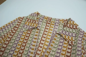 Detailed view of handmade crochet wave pattern and openwork knit texture in retro colors
