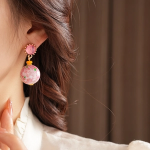 Détail de la boucle d'oreille vintage en céramique avec perle florale sur un mannequin