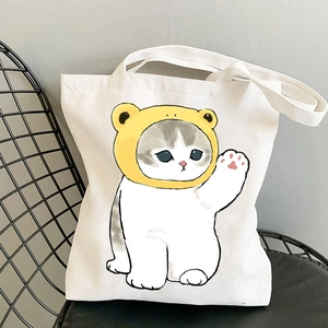 White canvas tote bag featuring a cute cartoon cat print on a black mesh chair