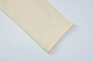 Close-up of pale yellow knit fabric showing ribbed cuffs and fine vertical texture