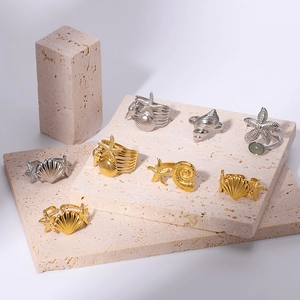 Minimalist 18k gold and silver starfish shell open rings set on stone pedestals
