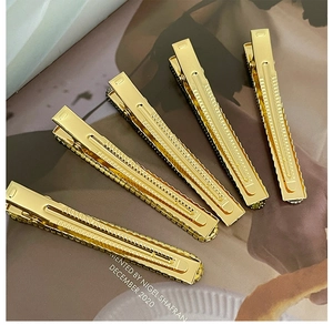 Close-up of five sparkling rhinestone hair clips on a golden base in a parallel layout