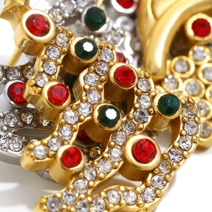 Macro view of 18K gold plated double C brooch with festive red and green rhinestones