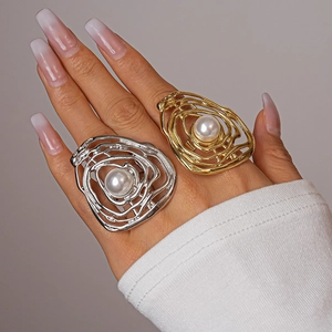 Close-up of irregular wave gold and silver rings with pearls on fingers