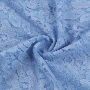 Dettaglio macro del tessuto in pizzo blu con delicati ricami floreali e trama fine