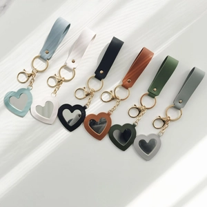 Heart-shaped mirror keychain pendants in various PU leather colors with gold metal rings