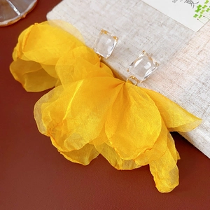 Details von gelben Tüllblüten-Ohrringen mit quadratischem Kristall auf Leder und Leinen
