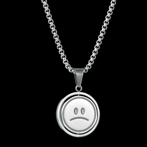 Rotating stainless steel smiley face necklace featuring a silver crying face pendant