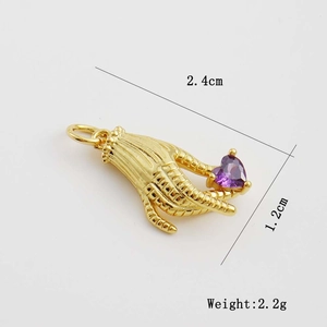 Détail d'un pendentif en forme de main tenant un cristal de cœur violet doré à l'or 18K