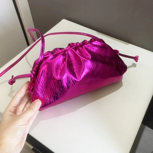 Detailed view of pink metallic cloud clutch bag with textured pleats and shoulder strap