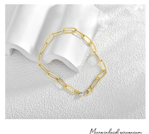 Detail eines vergoldeten Büroklammer-Armbands mit einem mikroeingelegten Zirkonia-Anhänger