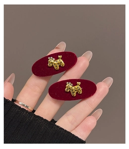 Detail of red flocked puppy hair clips with gold-tone accents and sparkling rhinestones