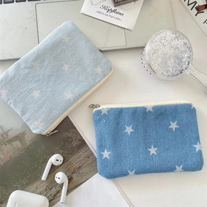Detailed view of star print denim coin purses styled with daily lifestyle accessories