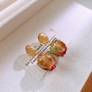 Vintage titanium steel earrings with golden textured discs and real dried rosebuds