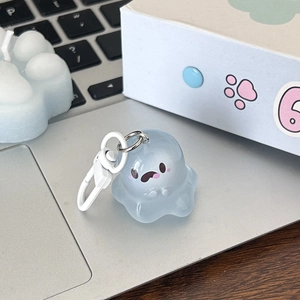 Close-up of a translucent light blue jelly ghost keychain on a laptop keyboard