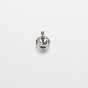 Close-up of polished silver stainless steel round pendant tray with top bail attachment