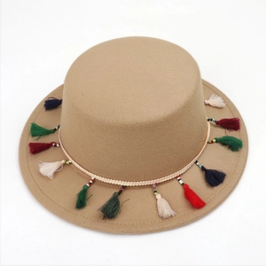 Détail d'un canotier camel avec des glands colorés et une bordure ethnique perlée