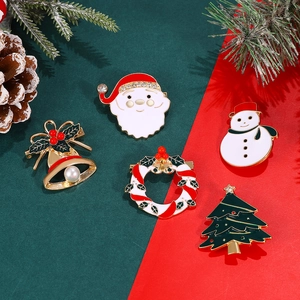 Detailed close-up of 5 Christmas enamel brooches with rhinestones and pearls on a festive background