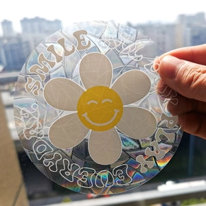 Holographic suncatcher sticker with Smile Every Day text and yellow flower detail
