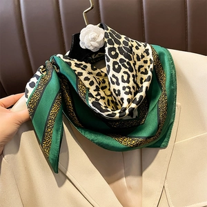 Elegant emerald and leopard print silk-feel square scarf styled on a beige blazer dress
