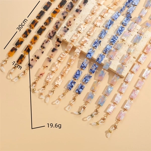 Resin link eyeglass chain in leopard and marble patterns on a stone display