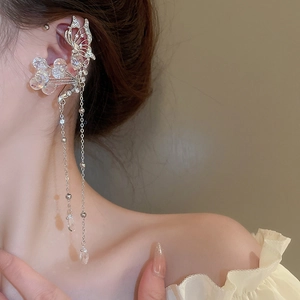 Detailed view of silver butterfly ear cuff with crystal flowers and long tassels