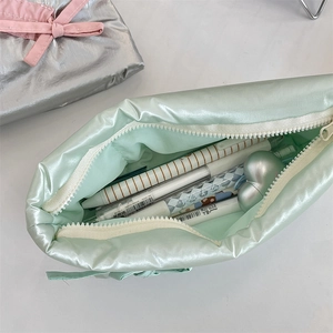 Macro shot of mint green silk pencil case showing interior capacity and glossy texture