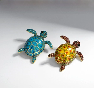Detail of colorful enamel turtle brooches with sparkling rhinestones in gold finish