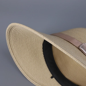 Close-up of fine woven texture and champagne ribbon bow on a summer straw hat