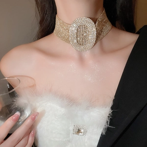 Close-up of luxury gold-tone wide choker necklace with oval rhinestone centerpiece