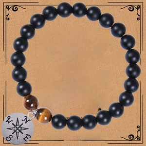 Detail of beaded bracelet with black onyx, tiger eye stones and silver compass charm