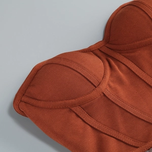 Dettaglio ravvicinato del top a corsetto rosso mattone con maglia a coste e cuciture sagomate