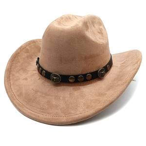 Detail of khaki suede cowboy hat featuring vintage bull head badge and metal studs