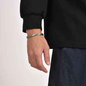 Close-up of vintage silver twisted rope stainless steel open bangle on male wrist