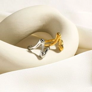 Macro shot of liquid wave style stainless steel rings in polished gold and silver finishes