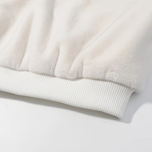 Détail du tissu peluche blanc et de l'ourlet en tricot côtelé d'une veste
