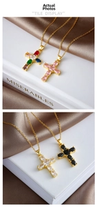 Detail view of colorful cross necklaces with gemstones on golden chain and silk background
