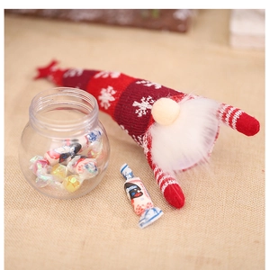 Detail of Christmas gnome candy jar with red knit hat and transparent storage bottle