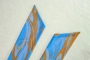 Détail de l'imprimé marbré bleu et orange sur tissu avec bord de ruban pointu