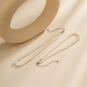 Detailed view of layered faux pearl necklace with silver lobster clasp and extension chain