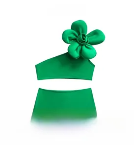 Détail d'un maillot de bain vert deux pièces avec une grande fleur 3D sur l'épaule