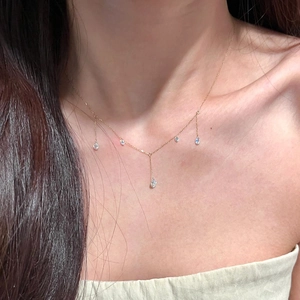 Close-up of elegant gold chain necklace with five dangling pear-cut zircon tassels