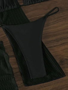 Detailed view of black mesh fabric texture and bikini bottom on dark wooden background